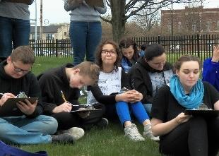 Students writing on their notes at a field day activity held by Michigan Environmental Education Curriculum Support